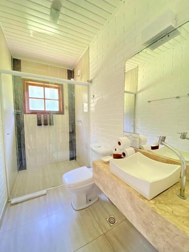 a bathroom with a sink and a toilet and a shower at Ilha de Toque Toque Eco Hotel in São Sebastião