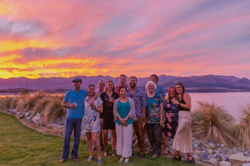 a group of people posing for a picture at sunset at Lakestone Lodge in Lake Pukaki