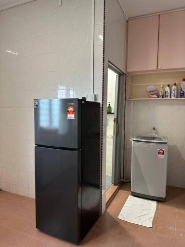a black refrigerator and a trash can in a kitchen at JEKK Home - Homestay KT in Kuala Terengganu
