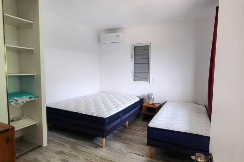 Zimmer mit 2 Betten, einem kleinen Bett und Regalen in der Unterkunft Painapoo - Mirimiri Lodge in Tevaitoa