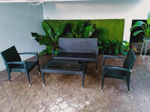 three chairs and a table in a room with plants at JJP Dormitel in Molave