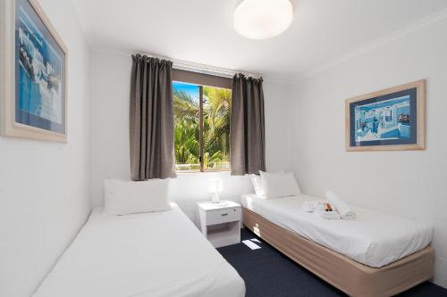 a hotel room with two beds and a window at Noosa International Resort in Noosa Heads