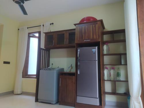 a kitchen with a refrigerator and a shelf at Kandy Lotus Chalet in Kandy