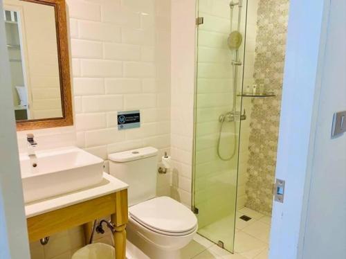 La salle de bains est pourvue de toilettes et d'une douche en verre. dans l'établissement Panphuree Residence - SHA Extra Plus, à Nai Yang Beach