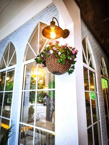 a basket of flowers hanging from a building with a window at เรินนายหัว by KOYAD RESORT in Ban Wat Khao