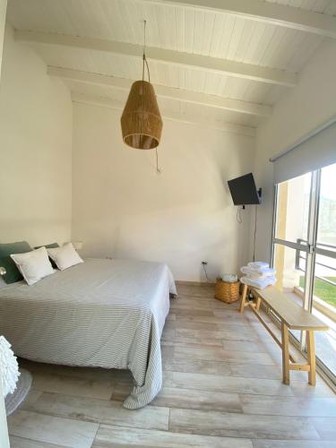 a bedroom with a bed and a table and a window at Benarés in Puerto Madryn