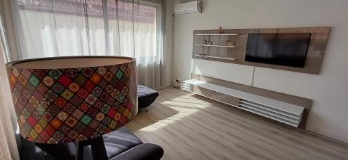 a living room with a tv and a couch and a chair at Vila Zeus in Cristian