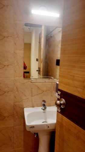 a bathroom with a sink and a mirror at Hotel Skyking in Gauripur