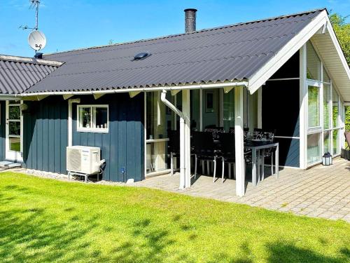 a blue house with a deck with a table at 4 star holiday home in Nordborg in Nordborg