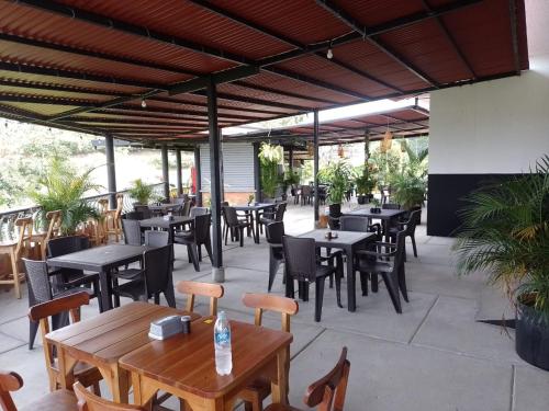 um pátio exterior com mesas e cadeiras e um restaurante em Hotel Maranta em Pereira