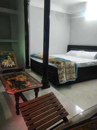 1 dormitorio con 1 cama, mesa y sillas en Jaipur BackPackers, en Jaipur