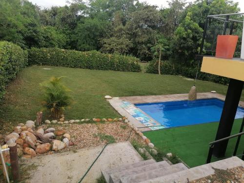 een achtertuin met een zwembad en een tuin bij Finca de descanso y diversión in Tocaima