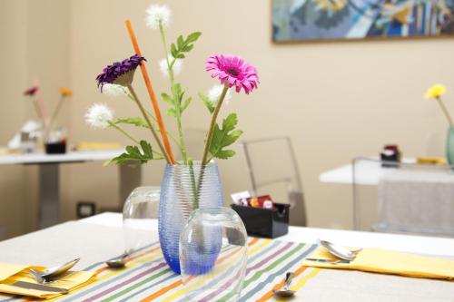 a blue vase with flowers in it on a table at Meublé Leonetti in Palinuro