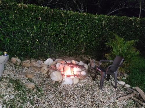 een vuurplaats in een tuin met een stoel bij Finca de descanso y diversión in Tocaima