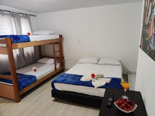 a bedroom with two bunk beds and a table with a bowl of fruit at Absolute Hotel & Hostel Boutique in Medellín