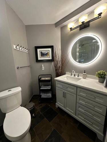 uma casa de banho com um WC, um lavatório e um espelho. em Luxury Two Queen Beds Condo - Grande Rockies Resort Indoor Parking Pool Hot tub GYM em Canmore