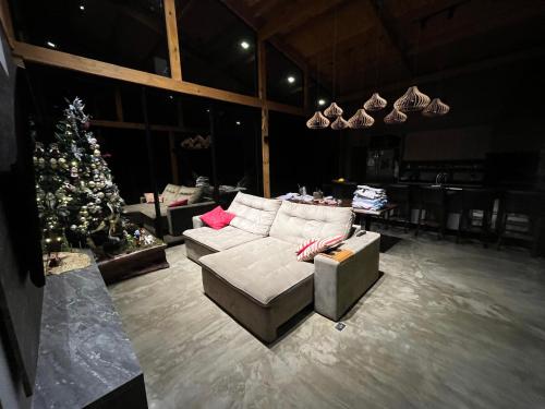casa de campo rústica para show rural في كاسكافيل: غرفة معيشة مع أريكة وشجرة عيد الميلاد