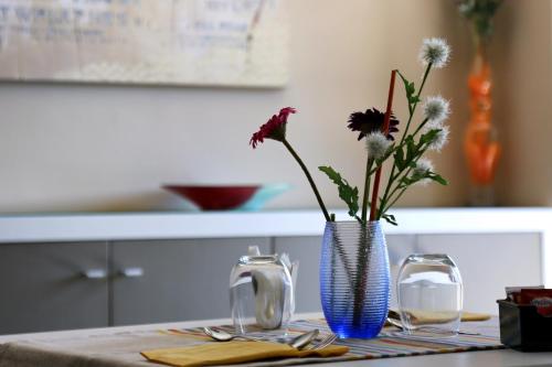 a table with a blue vase with flowers in it at Meublé Leonetti in Palinuro