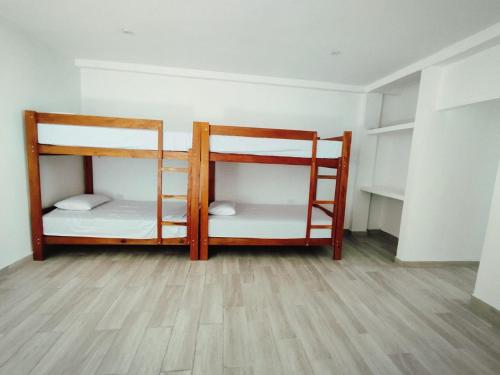 two bunk beds in a room with a wooden floor at BUNGALOWS CASAMAR in Tumbes