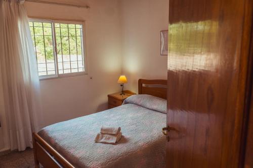 a small bedroom with a bed and a window at Cabañas Madrid in Alta Gracia