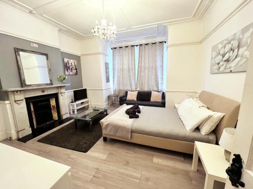 a living room with a bed and a fireplace at Norbury House - Apartment 1A in Norbury