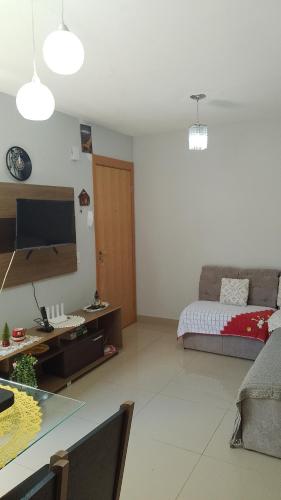 a living room with a couch and a table with a television at Castelo Di Palmas in Campo Grande