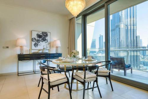 a dining room with a table and chairs and a large window at FIRST CLASS 3BR with full BURJ KHALIFA and FOUNTAIN VIEW in Dubai