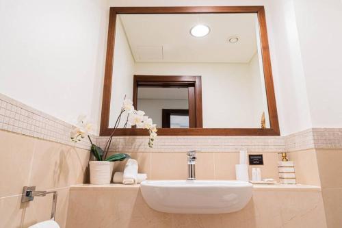 a bathroom with a sink and a large mirror at FIRST CLASS 3BR with full BURJ KHALIFA and FOUNTAIN VIEW in Dubai