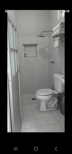 a white bathroom with a toilet and a sink at Departamento por plaza terraza oblatos in Guadalajara