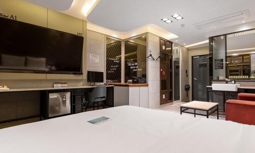 um quarto com uma cama e uma televisão de ecrã grande em Pohang A1 Hotel Yeongildae Branch em Pohang