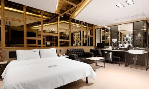 ein Schlafzimmer mit einem großen Bett und einem Schreibtisch in der Unterkunft Pohang A1 Hotel Yeongildae Branch in Pohang