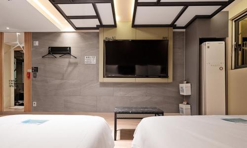 a bedroom with a flat screen tv on a wall at Pohang A1 Hotel Yeongildae Branch in Pohang