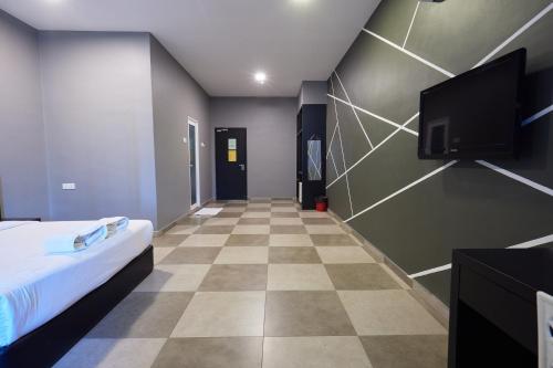 a room with a bed and a flat screen tv at Elite Hotel Muar in Muar