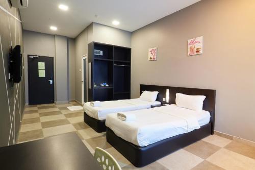a hotel room with two beds and a tv at Elite Hotel Muar in Muar