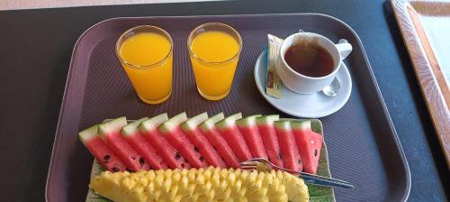 una bandeja con un plato de fruta y una taza de café en Lanta Summer House 1, en Ko Lanta