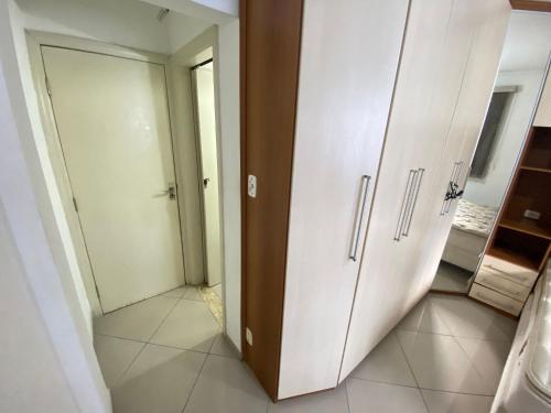 a bathroom with a closet and a door in a room at Pé na areia canto do forte II in Praia Grande
