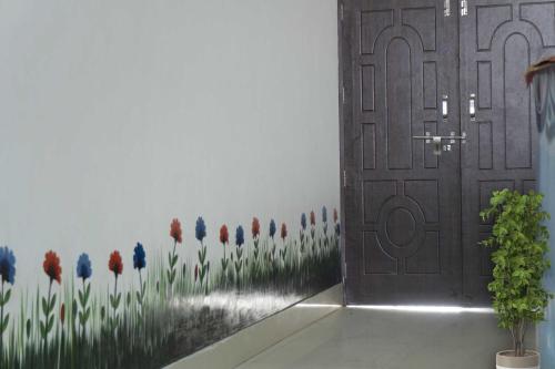 a door with a painting of red and blue flowers at Flagship Rimjhim Garden & Hotel in Patna