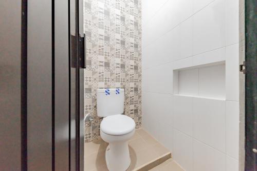 a small bathroom with a toilet and a shower at Urbanview Hotel Sunday Cirebon by RedDoorz in Cirebon