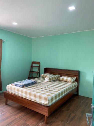 - une chambre avec un lit dans une pièce aux murs bleus dans l'établissement Villa Adendri Riverhills, à Megamendung