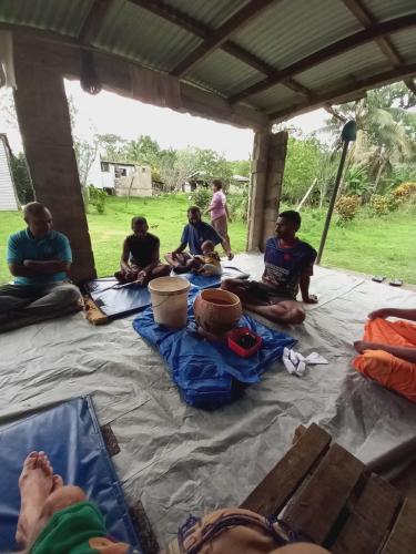 un groupe de personnes assises sur une couverture dans l'établissement Highlands Homestay Fiji, à Mbukuya