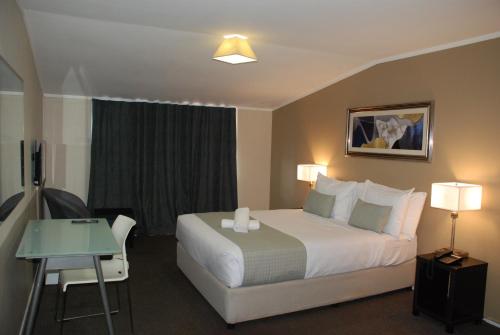 a hotel room with a bed and a table at Aero Auckland Airport in Auckland