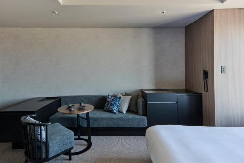 a hotel room with a couch and a bed at The Royal Park Hotel Iconic Nagoya in Nagoya