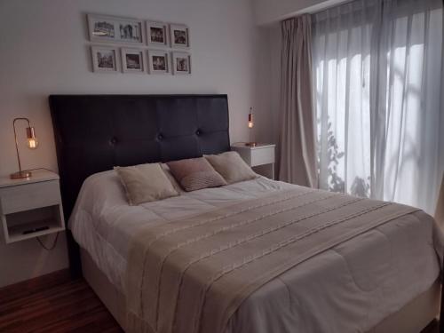 een slaapkamer met een groot bed en een groot raam bij Moderno 2amb con cochera in Mar del Plata