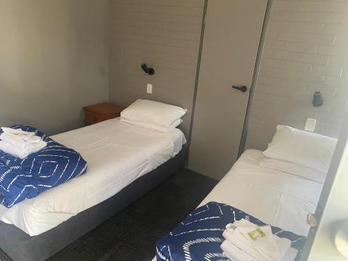 two beds in a small room with towels on them at Rod 'N' Reel Hotel Motel Woodburn in Woodburn