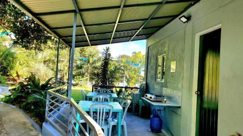 een patio met een tafel en stoelen op een veranda bij Hidden Palms Inn/Resort La Union in San Juan