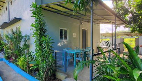 un patio con una mesa azul y algunas plantas en Hidden Palms Inn/Resort La Union, en San Juan
