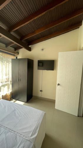 a bedroom with a white bed and a white door at apartamento entero en santa Gema interior 202 in Medellín
