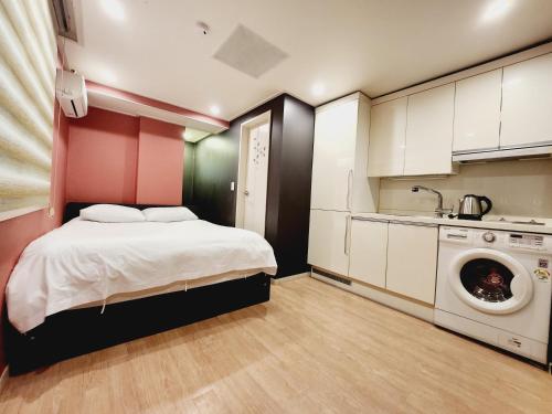 a bedroom with a bed and a washing machine at Olive hostel R(Residence) in Seoul