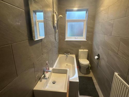 a bathroom with a sink and a tub and a toilet at Commuters Getaway in Chesterfield