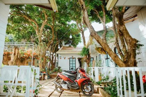a red motorcycle parked in front of a house at Homestay Vườn nhãn in Pleiku